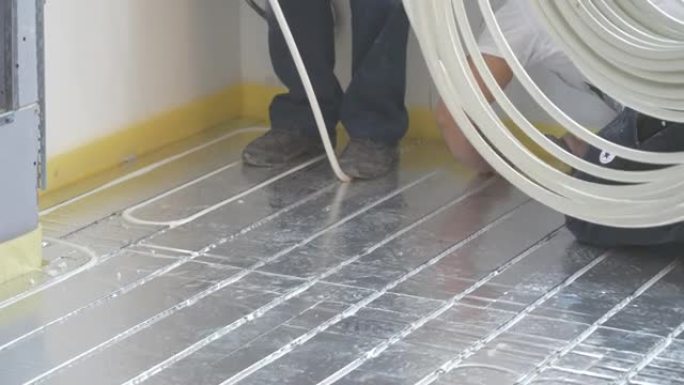 为加热地板安装电缆的工人。