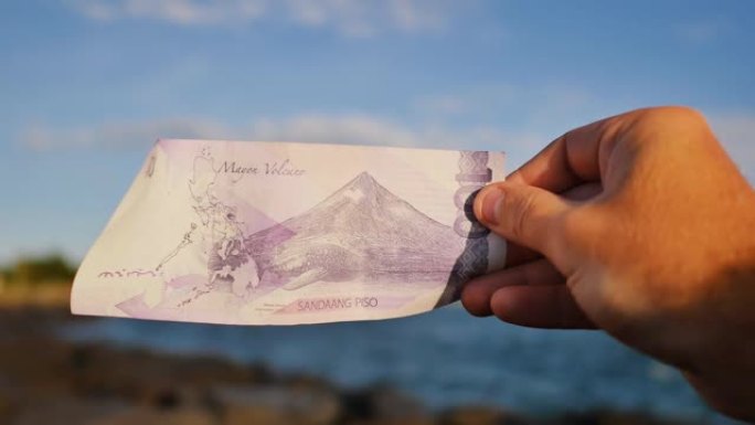 菲律宾的钱。100比索的菲律宾货币纸币专用于马永火山