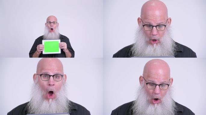 展示数字平板电脑的成熟秃头大胡子男人的脸