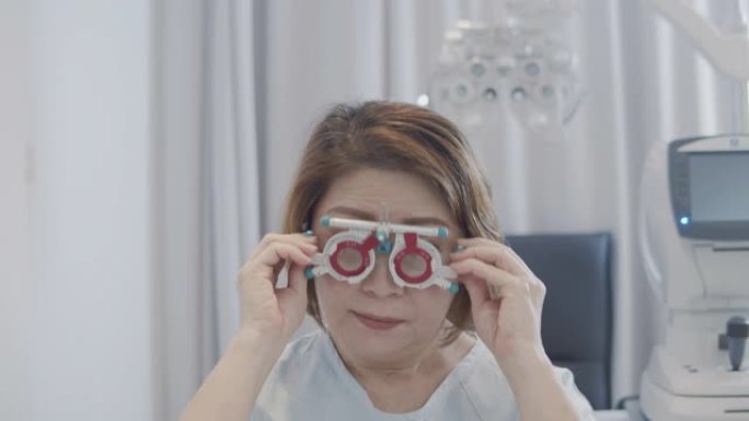 由医生在验光师商店检查眼睛的亚洲高级女性患者。使用自动折射仪，phoropter，trial fra