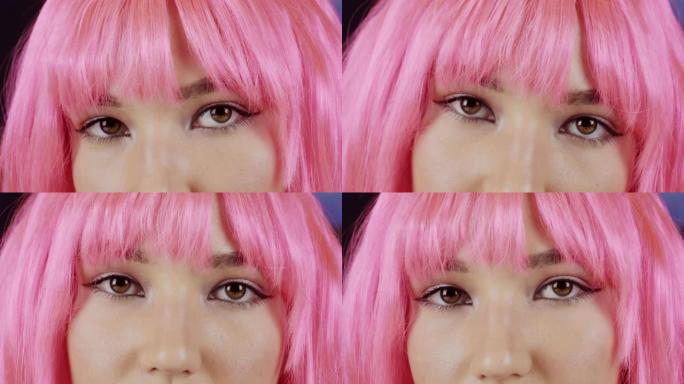 美丽的粉红色头发的年轻女子看着镜头。