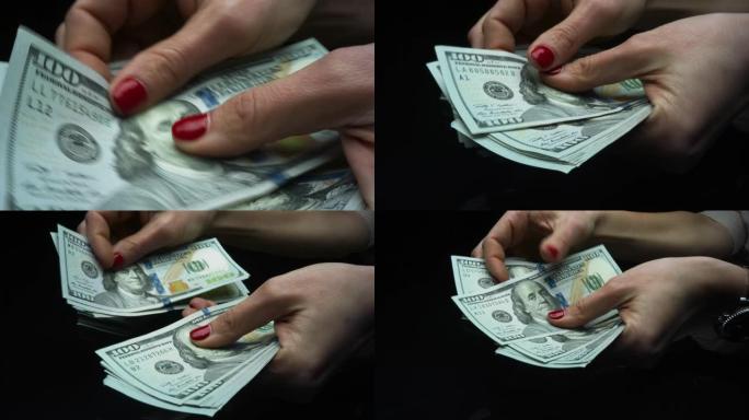 女人检查现金金额。手握100美元钞票
