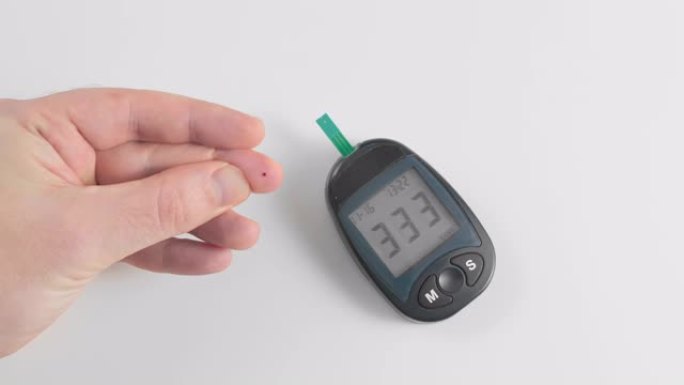 一个无法识别的人测量血糖葡萄糖。用笔刺穿手指的皮肤，并在放置的测试条上滴一滴血。糖尿病的概念预防