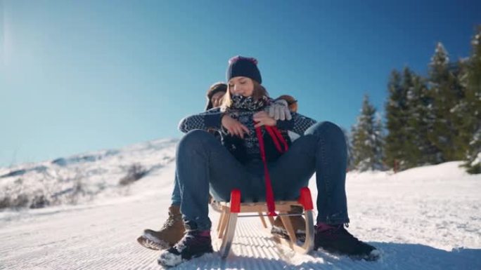 幸福的夫妻在雪山上骑着新的雪橇