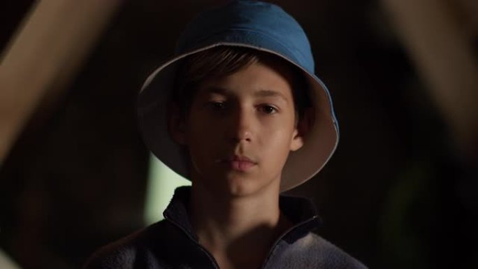 一个戴着蓝色帽子的男孩在室内看着相机的肖像