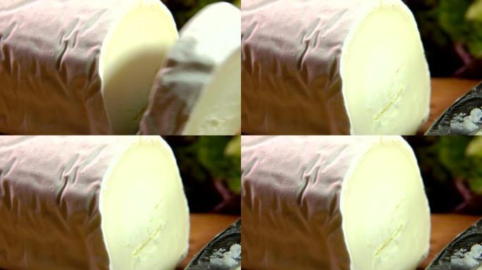 在蔬菜的背景上用刀切的圣莫雷德都兰奶酪