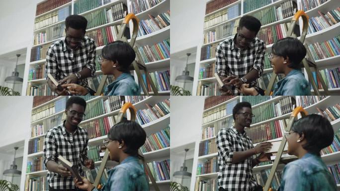 非洲男孩站在梯子上，在大学图书馆给非洲女孩送书
