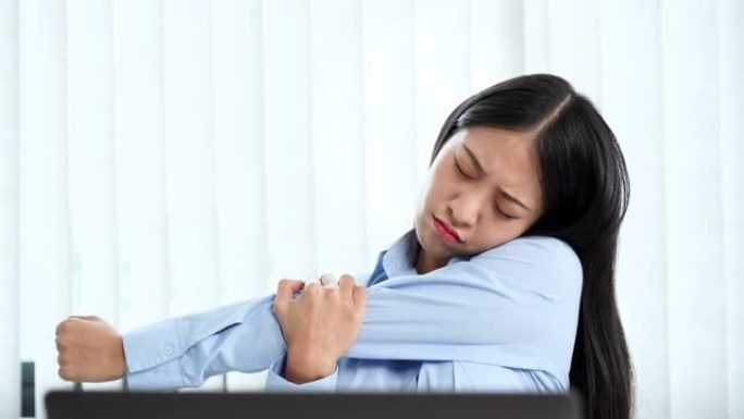 4k视频录像，年轻的亚洲女商人在办公室的笔记本电脑上努力工作，并因颈部疼痛，热身和运动而伸展运动