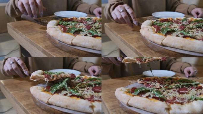 女人的手从餐厅的木盘里拿了一片披萨。慢动作