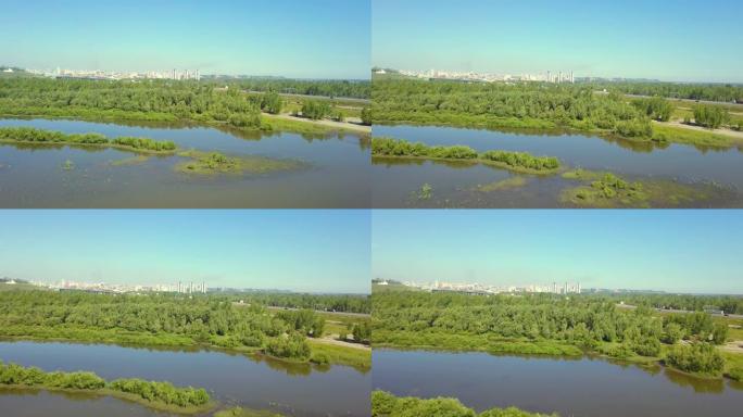 空中: 飞越沼泽地，朝着高速公路，桥梁和城市景观飞行。骑汽车和卡车。