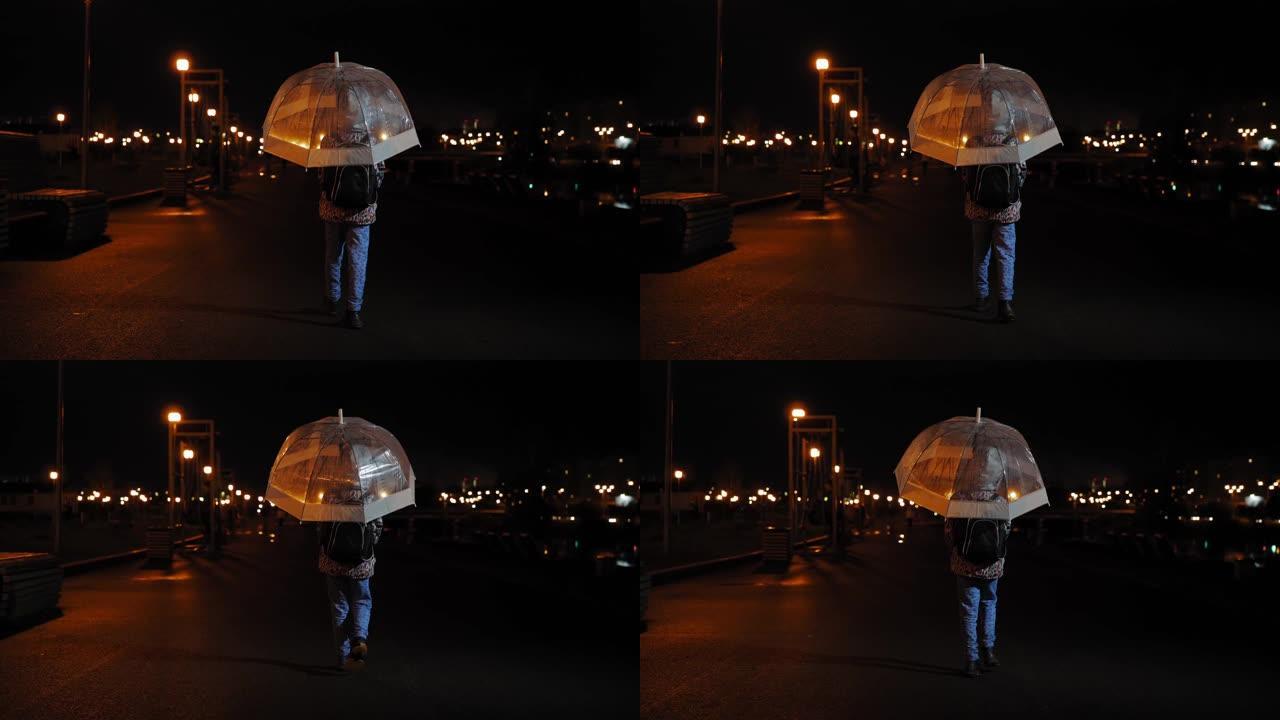 儿童在雨中黑暗中在雨伞下行走的后视，慢动作。