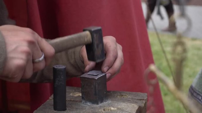 铁砧里的手工造币。古代俄罗斯艺术。用锤子铸造硬币。