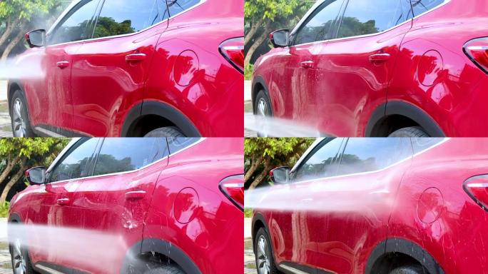 工人手持高压喷水器洗车特写。