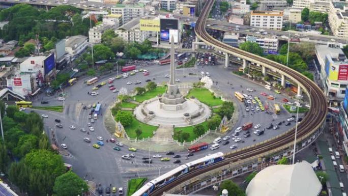 繁忙街道路上胜利纪念碑的鸟瞰图。曼谷市中心天际线的环形交叉路口。泰国。智慧城市金融区中心。日落时的摩