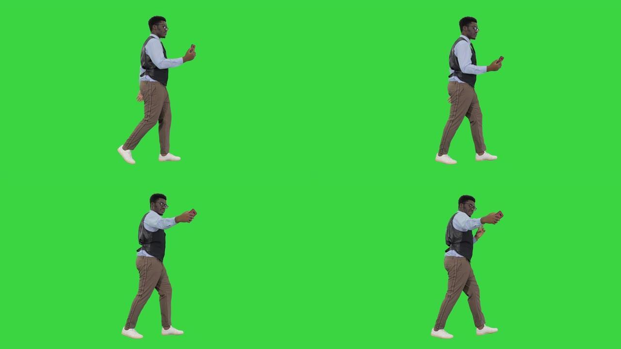非裔美国商人在绿屏上行走时用手机自拍，色度键