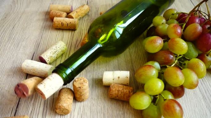 在酒瓶和葡萄的背景下，在木板上掉落的软木塞。慢动作。