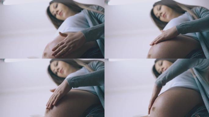 孕妇在家特写镜头在肚子上涂抹乳液