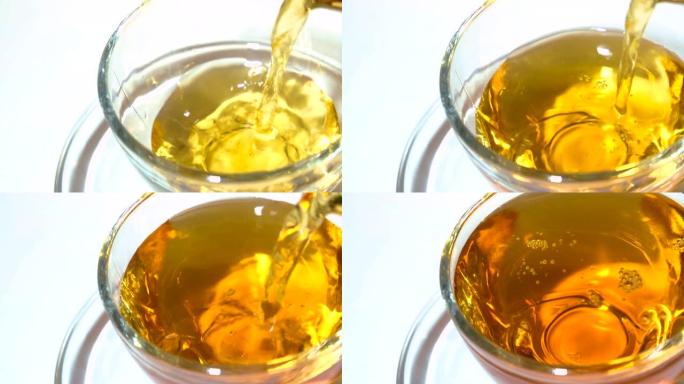 将茶壶中的芳香红茶倒入白色背景特写相配的透明玻璃茶杯中