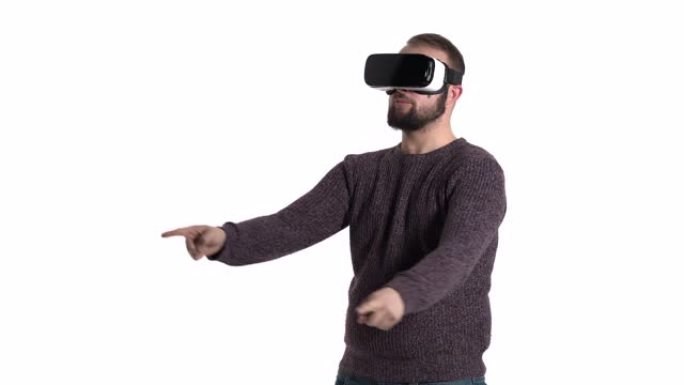 大胡子男人正在玩虚拟现实眼镜。人在空中画假想的圆圈，享受新的体验。酷高科技设备使用概念。