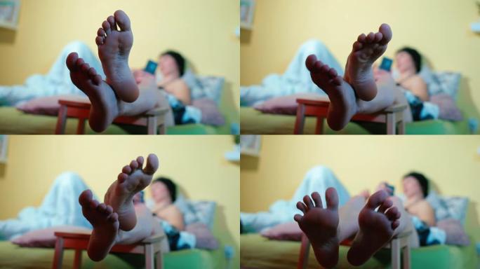 一个女人躺在床上的脚。