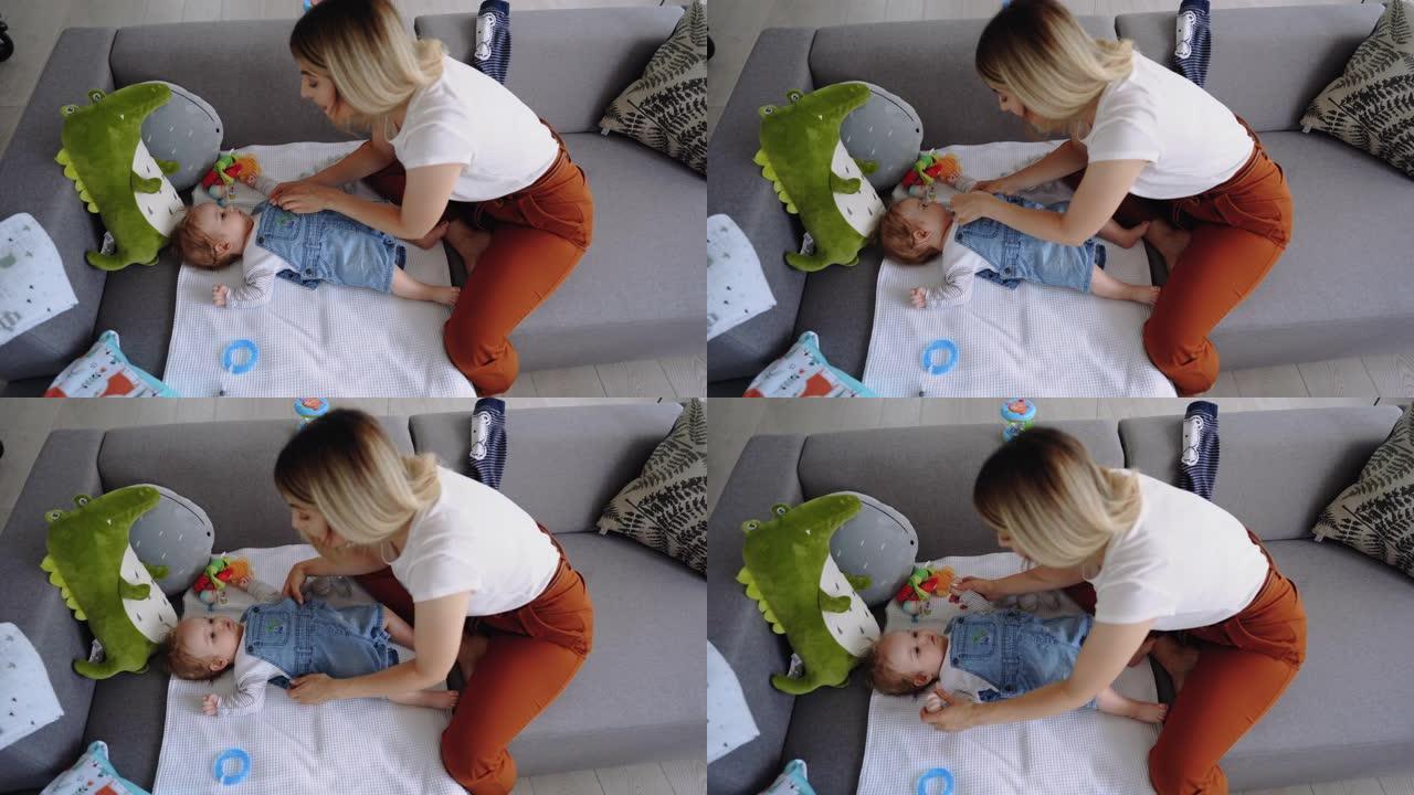 年轻的单身母亲和她的男婴在沙发上玩耍