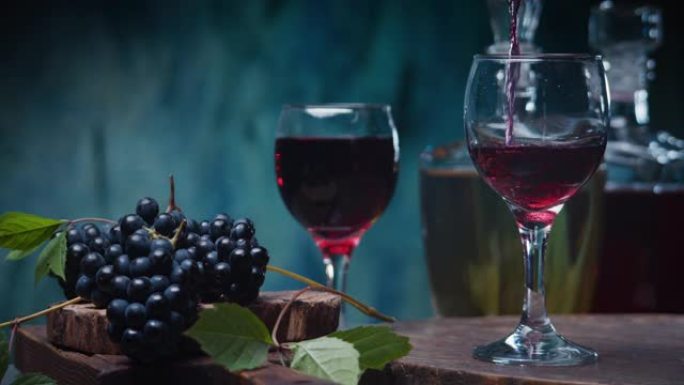 用红葡萄和葡萄酒瓶在蓝色背景下倒红酒