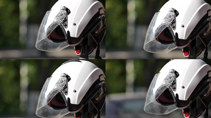 路边停放的摩托车上的白色摩托车头盔。自行车驾驶员保护器
