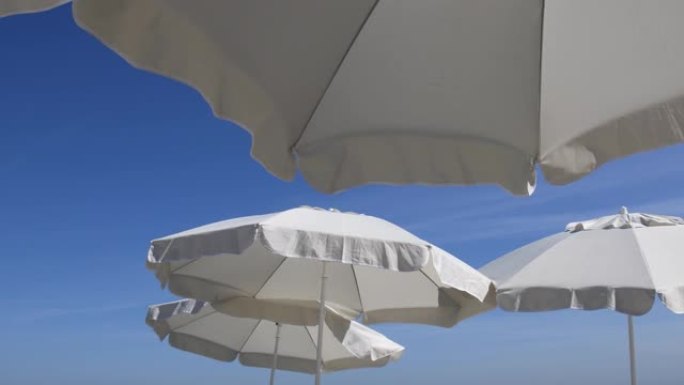 白色沙滩伞在湛蓝的天空下。旅游假期的象征