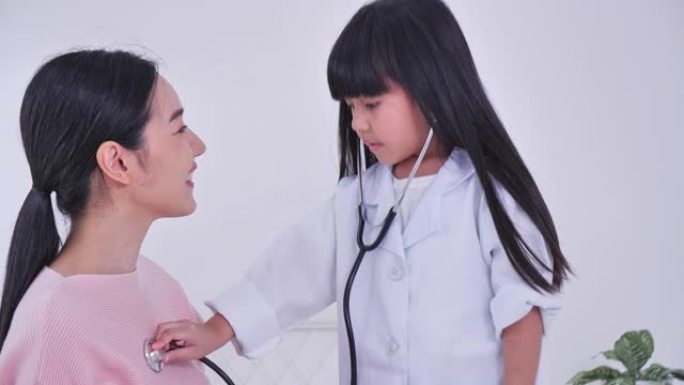 妈妈看看女儿肩膀上穿着白色医生外套听诊器，和医生想象自己，玩游戏概念