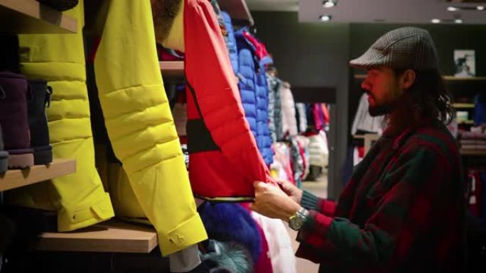 男人在寒假去购物，看衣服。我们可以看到冬装，非常适合去山里滑雪 -- 近景4K