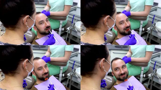 一名患者正在咀嚼特殊的牙科指示器，牙医正在检查它