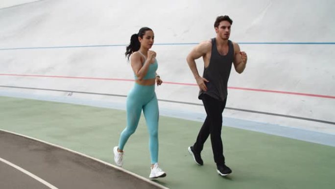 健身夫妇在现代体育场一起训练。运动情侣跑步