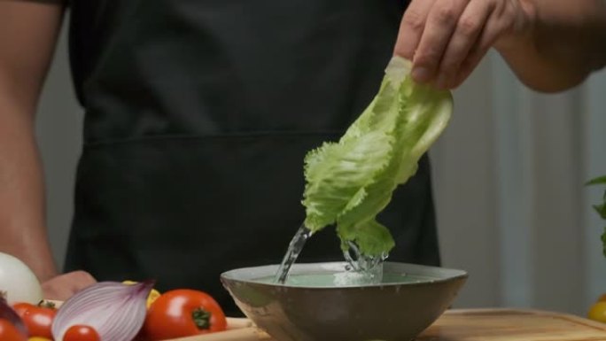 专业厨师洗卷心菜叶。慢动作