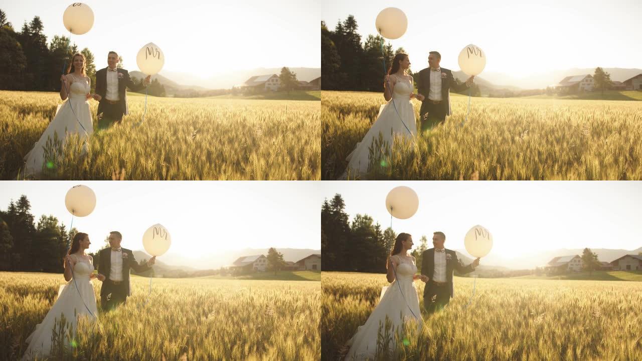 一对新婚夫妇站在麦田里抱着先生和女士。气球