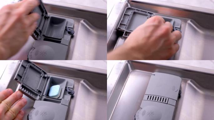 男人的手正在将洗涤剂片放在洗碗机的自动隔间中。