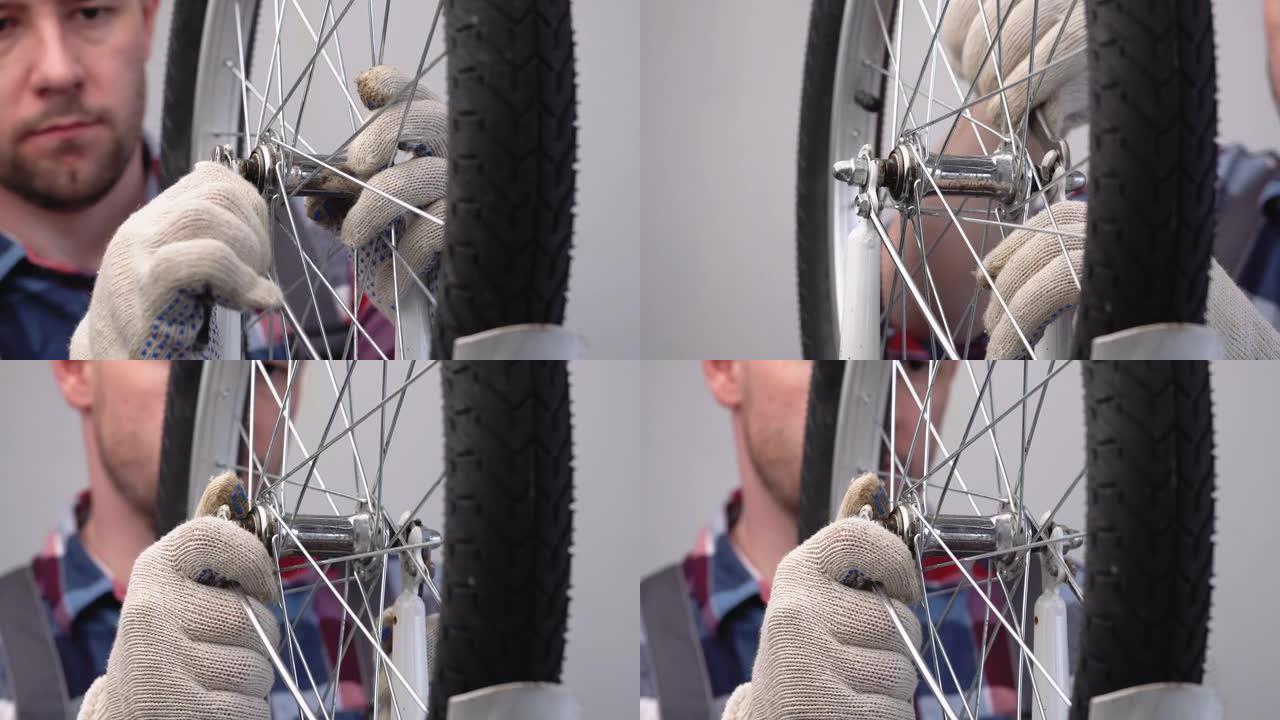 自行车的维修和保养。男性修理工用扳手拧紧轮毂轴上螺母的特写镜头。安装自行车的前轮。