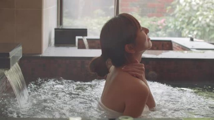 亚洲年轻女子在温泉中放松和按摩