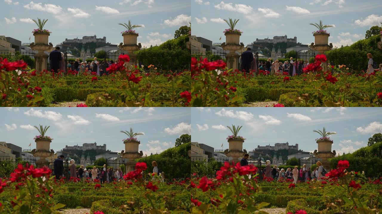 阳光明媚的夏日萨尔茨堡市著名旅游拥挤花园玫瑰慢动作全景4k奥地利