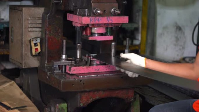 该机器的工作原理是从工人控制的长钢板上冲压出一个圆圈。