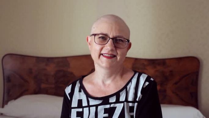 接受化疗后的成熟秃头女人看着镜头微笑