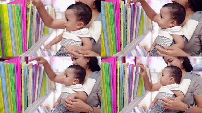 一个亚洲男婴，母亲抱着书店。