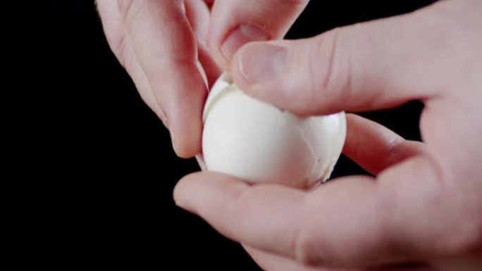 男人的手从蛋壳上清洗煮鸡蛋。