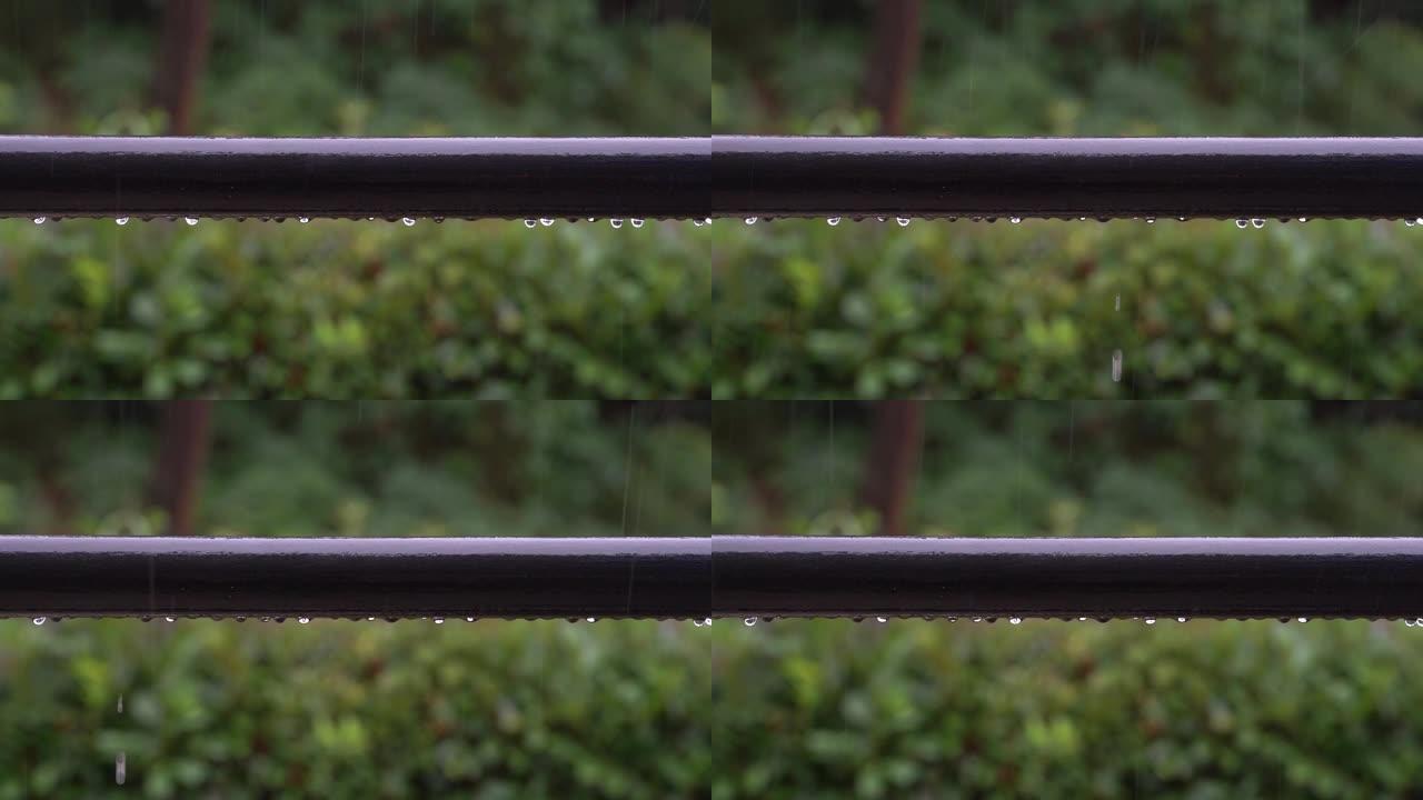 雨滴落在阳台栏杆上，并在大雷雨中滑落