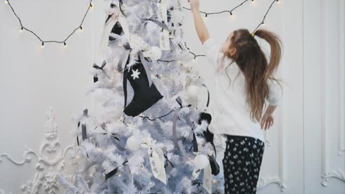 小女孩试图从圣诞树的顶部到达星星，她跳了起来，但失败了。