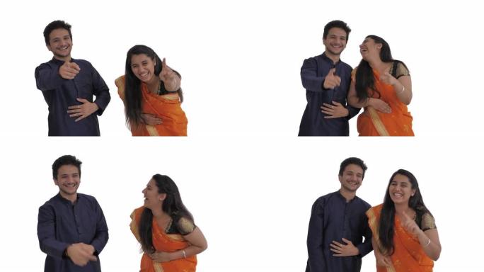 年轻的印度夫妇嘲笑某人，嘲笑并指向镜头。孤立在白色背景上。