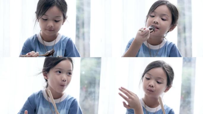 亚洲女孩在家一起在地板上吃巧克力纸杯蛋糕，生活方式理念。