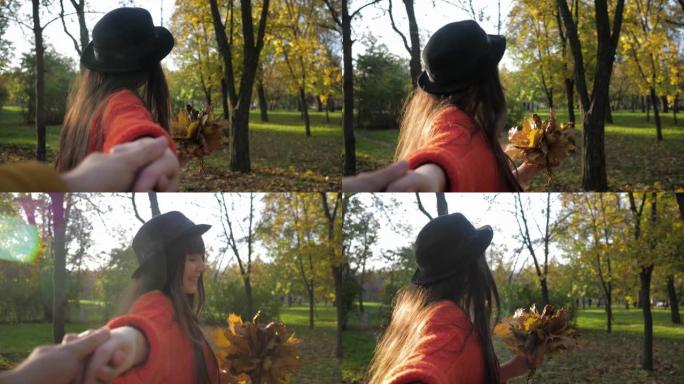 跟我来，戴着帽子的年轻有趣的女人在秋季公园散步时欢快地奔跑，握着朋友的手