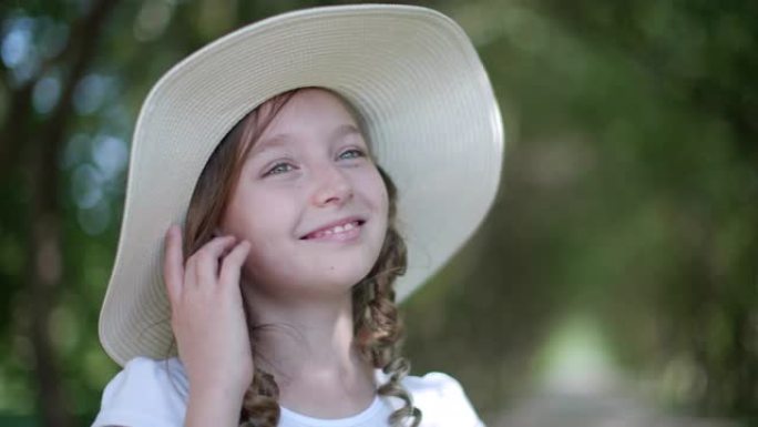 穿着白色夏日帽的浪漫女孩肖像。夏日公园里戴着白帽子的微笑女孩少年特写脸。绿色花园里的漂亮女孩模特。