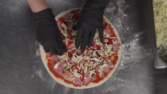 披萨厨师在专业厨房烹饪的空中镜头。Pizzaiola在比萨饼上放奶酪层。意大利传统食品