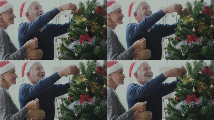 年长的高加索老人老人和女人装饰圣诞树以准备圣诞节节日